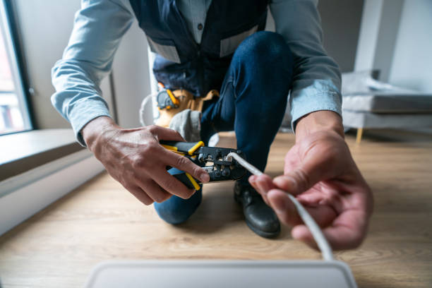 Internet technician installing a router at a house and cutting the cable Internet technician installing a router at a house and cutting the cable